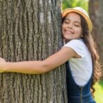 medium-shot-smiley-little-girl-hugging-tree_23-2148260053-1